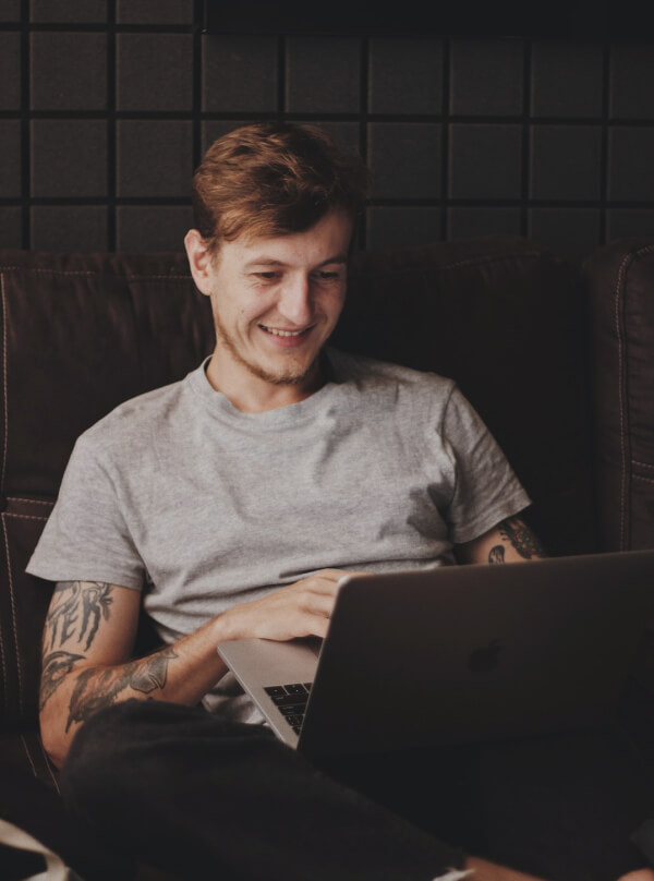 A smiling digital marketing coach working on a laptop